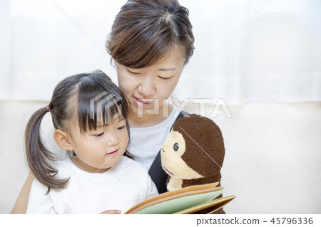 A mother who reads a picture book using a puppet for a little girl. Reading, child care, education, parent and child image A mother who reads a picture book using a puppet for a little girl. Reading, child care, education, parent and child image 45796336