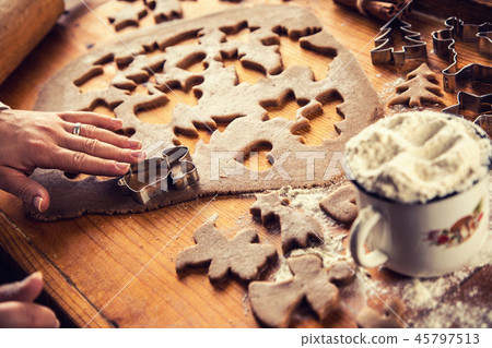 Gingerbread dough and woman hands preparing cakes. 45797513