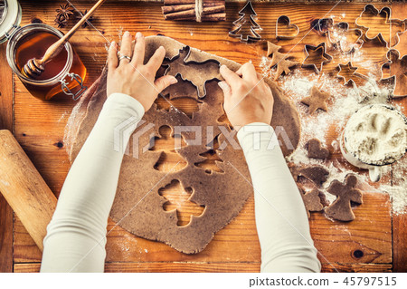 Gingerbread dough and woman hands preparing cakes. Gingerbread dough and woman hands preparing cakes. 45797515