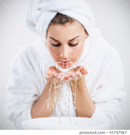 Young woman washing face with clean water. 45797967