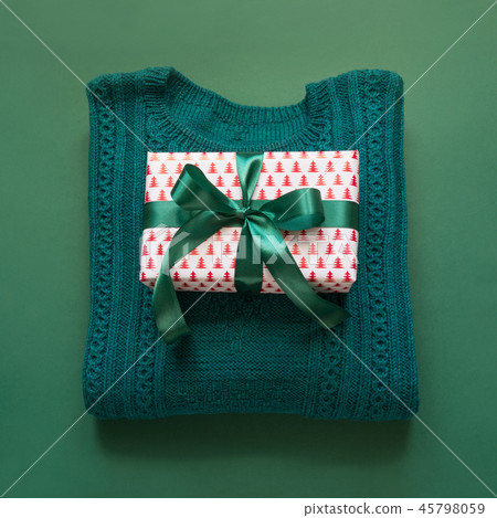 Christmas gift with ribbon, sweater on green. Christmas gift with ribbon, sweater on green. 45798059