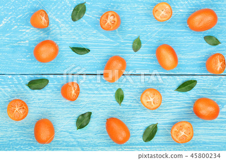 Cumquat or kumquat with leaf on blue wooden background. Top view. Flat lay pattern 45800234