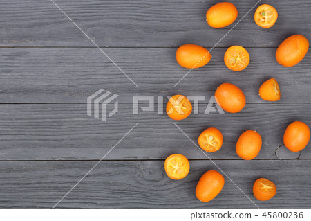 Cumquat or kumquat with half on black wooden background with copy space for your text. Top view Cumquat or kumquat with half on black wooden background with copy space for your text. Top view 45800236