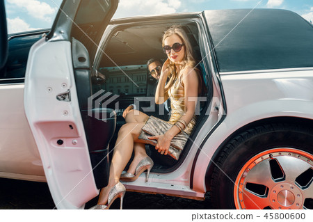 VIP Woman and man getting out of limousine VIP Woman and man getting out of limousine 45800600