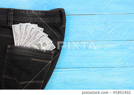 american dollar bills in jeans pocket on blue wooden background with copy space for your text. Top 45801402