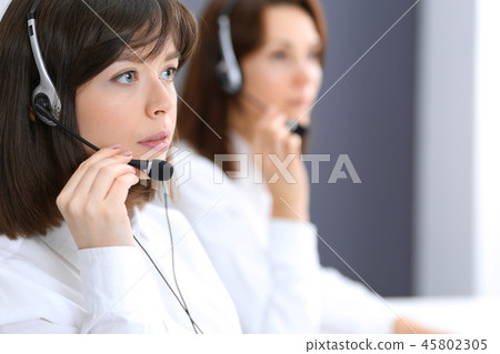 Call center. Group of operators at work. Focus on young brunette woman. Business  concept Call center. Group of operators at work. Focus on young brunette woman. Business  concept 45802305