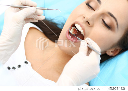 Young female patient visiting dentist office.Beautiful woman with healthy straight white teeth Young female patient visiting dentist office.Beautiful woman with healthy straight white teeth 45803480