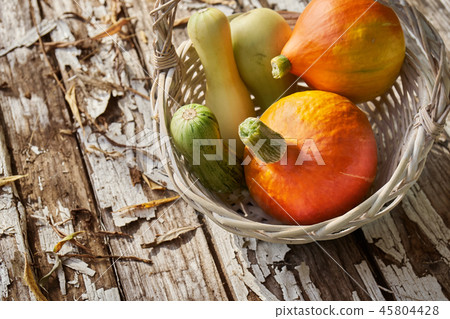 Still life with freshly collected vegetables in a wicker backet on the old wooden boards Still life with freshly collected vegetables in a wicker backet on the old wooden boards 45804428