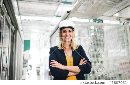 A portrait of an industrial woman engineer standing in a factory. A portrait of an industrial woman engineer standing in a factory. 45807081