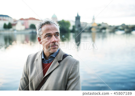 Mature businessman standing by river Vltava in Prague city. Copy space. Mature businessman standing by river Vltava in Prague city. Copy space. 45807189