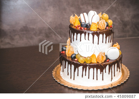 Delicious cake with fruit and berries decoration on wooden table Delicious cake with fruit and berries decoration on wooden table 45809887
