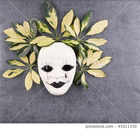 Stylized mask and tropical palm leaves on gray Stylized mask and tropical palm leaves on gray 45811330
