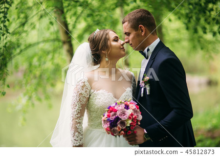 Groom and bride kiss each other in their wedding day Groom and bride kiss each other in their wedding day 45812873