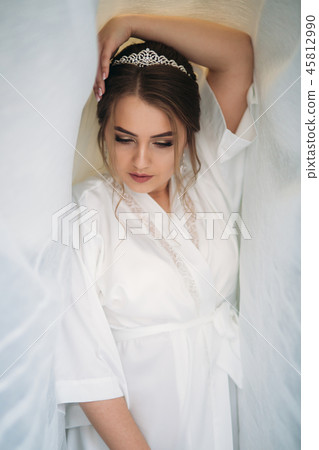 Portrait of the bride in a negligee under the white curtain Portrait of the bride in a negligee under the white curtain 45812990