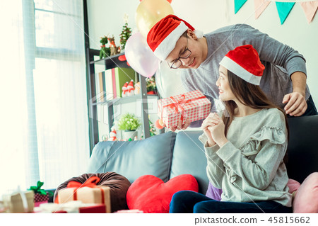 Christmas Gift. Asian Couple in Santa's Hat Christmas Gift. Asian Couple in Santa's Hat 45815662
