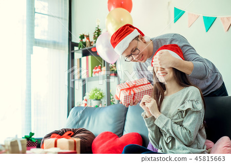 Christmas Gift. Asian Couple in Santa's Hat 45815663
