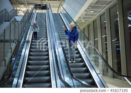 Mother and child together on escalator background. Terminal, airport travel, love care. Mother and child together on escalator background. Terminal, airport travel, love care. 45817195