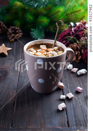 Hot cappuccino with marshmallows in a ceramic cup with honey and metal honey stick on a wooden dark 45817462