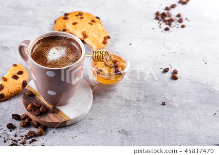 Coffee cup with chocolate cookies on stone background with honey and metal honey stick with copy Coffee cup with chocolate cookies on stone background with honey and metal honey stick with copy 45817470