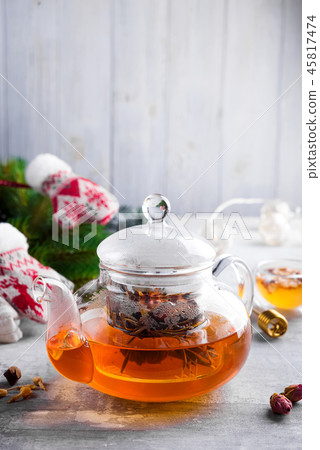 Glass teapot with flowers tied tea, Hot tea in glass teapot and honey with metal honey stick on 45817474