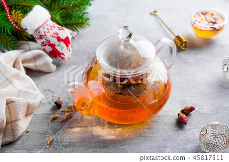 Glass teapot with flowers tied tea, Hot tea in glass teapot and honey with metal honey stick on 45817511