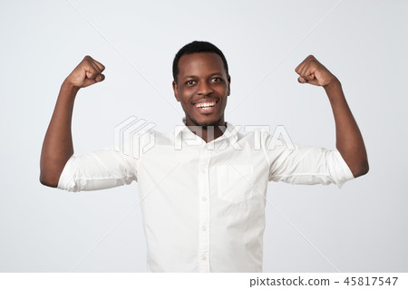 Portrait of a strong young african man in white shirt flexing biceps Portrait of a strong young african man in white shirt flexing biceps 45817547