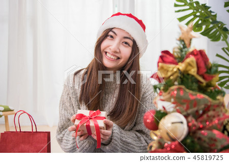 Happy young woman with credit card using laptop near Christmas t 45819725