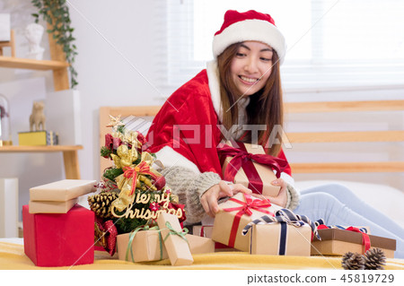 Smiling young woman with Christmas present box. 45819729