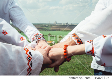people are dressed in traditional Ukrainian clothes holding their hands together, success 45821126