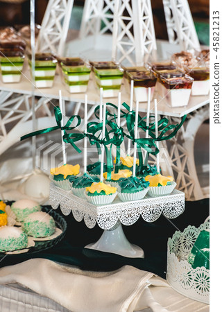 green style wedding candy bar on a white table. cupcakes decorated with a green ribbon bow 45821213