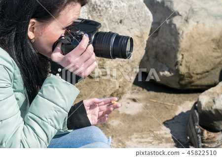 A girl with a camera taking pictures 45822510