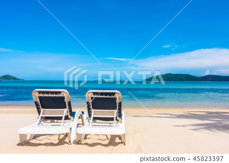 Beautiful outdoor view with umbrella and chair on the beach and sea Beautiful outdoor view with umbrella and chair on the beach and sea 45823397