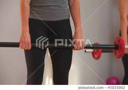 Group of Fit young women exercising with barbells 45833002
