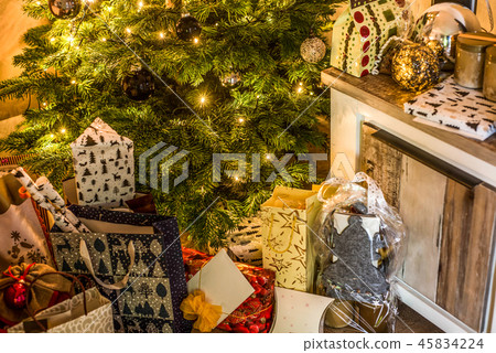 Small handmade gift boxes in shiny colorful night christmas tree setup background celebration 45834224
