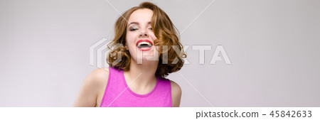 Charming young girl in pink dress on gray background. Young girl pulls her hand out Charming young girl in pink dress on gray background. Young girl pulls her hand out 45842633