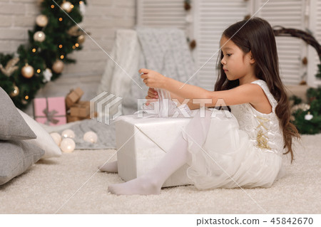Pretty smiling girl holding Christmas gift in hand 45842670