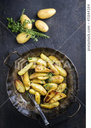 Roast Potatoes with herbs as top view in an iron c 45844164