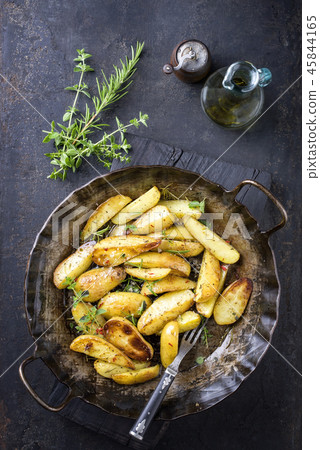 Roast Potatoes with herbs as top view in an iron c 45844165