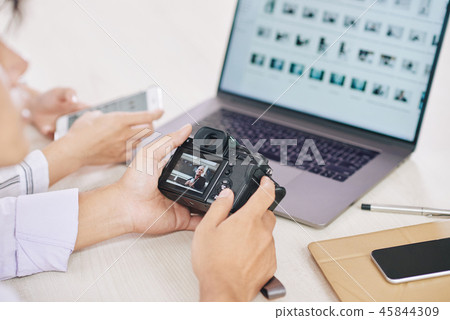 Crop photographers with laptop and camera 45844309