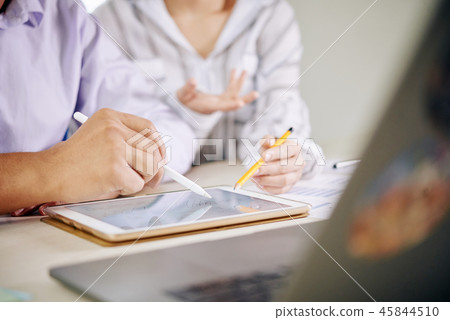 Coworking people watching tablet at desk 45844510