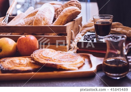 Baked breads, apples and coffee on a table. 45845489