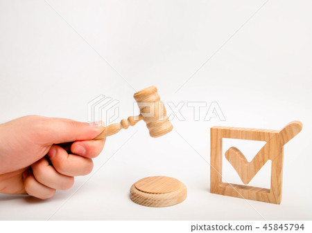 A wooden checkmark and a hammer of the judge  45845794