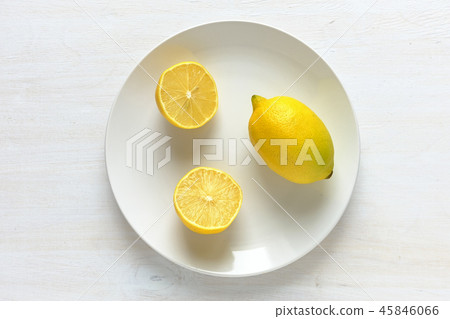 Lemon cut in half on plate with white copy space Lemon cut in half on plate with white copy space 45846066