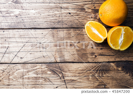 Pieces of fresh orange juice on wooden background. 45847200