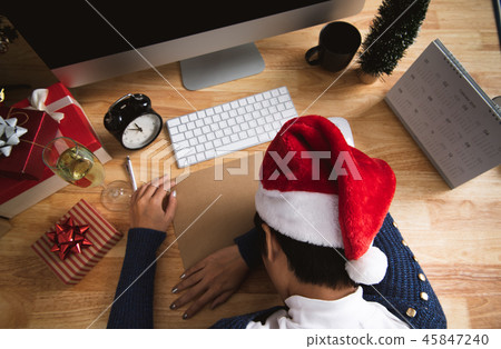 business woman with santa hat sleeping on desk business woman with santa hat sleeping on desk 45847240