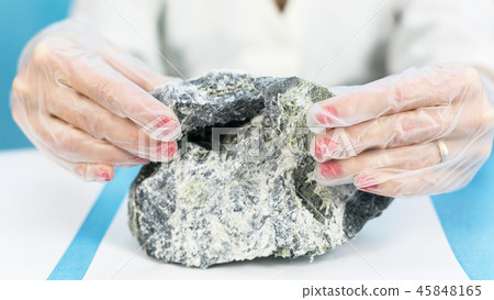 Female hands hold the dangerous mineral asbestos. 45848165