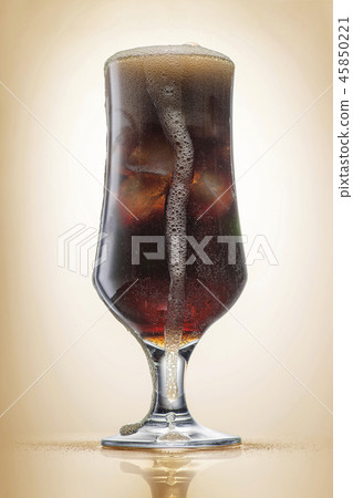 Crowded glass with cola and ice, light toning 45850221