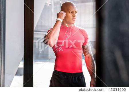 Handsome well built man putting on headphones 45851600