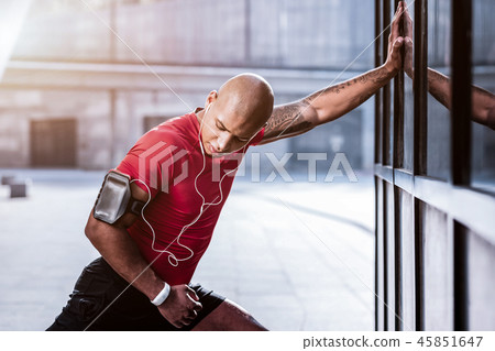 Handsome athletic young man looking at his hand 45851647