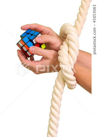 Cube puzzle with bandaged hands with a rope Cube puzzle with bandaged hands with a rope 45853063